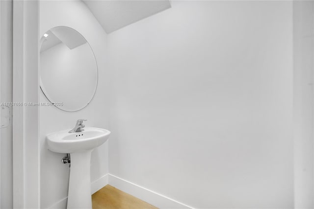 bathroom featuring a sink, baseboards, and wood finished floors