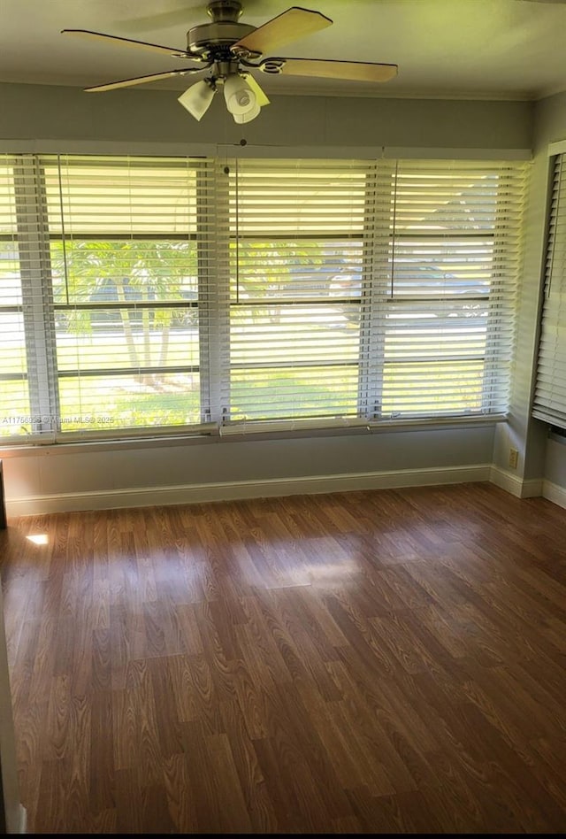 spare room with ceiling fan, baseboards, and wood finished floors