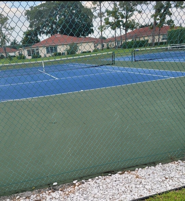 view of tennis court with fence