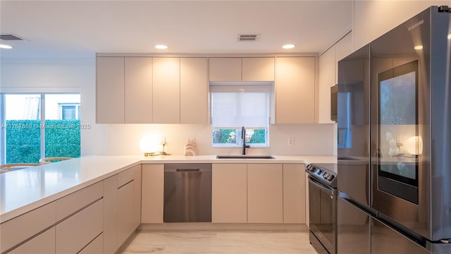 kitchen featuring visible vents, appliances with stainless steel finishes, light countertops, and a sink