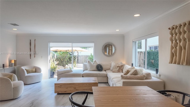 living room with ornamental molding, a wealth of natural light, and visible vents