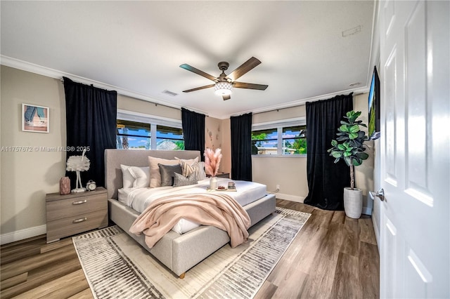 bedroom with visible vents, baseboards, and wood finished floors