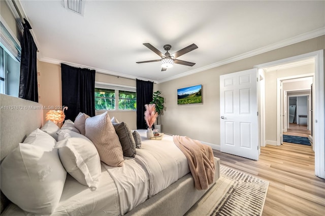 bedroom with crown molding, visible vents, light wood-style floors, ceiling fan, and baseboards