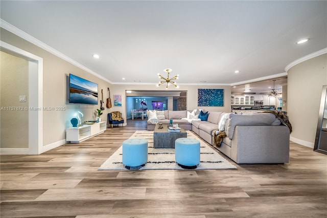 living area featuring wood finished floors, crown molding, and an inviting chandelier