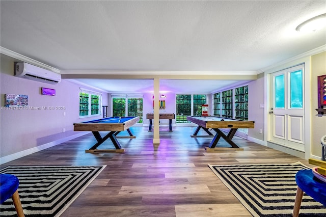 game room with ornamental molding, pool table, a wall mounted air conditioner, and wood finished floors