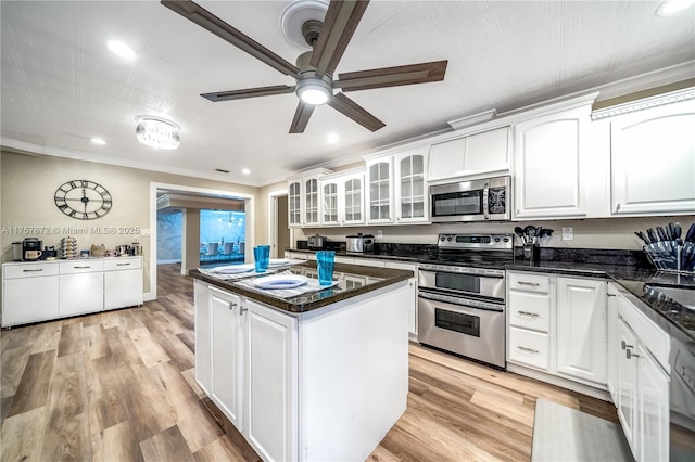 kitchen with light wood-style floors, a kitchen island, appliances with stainless steel finishes, and white cabinets