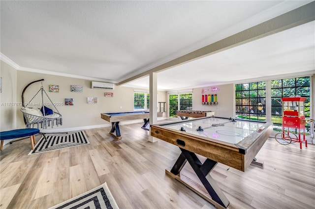 playroom featuring baseboards, an AC wall unit, light wood-type flooring, and crown molding