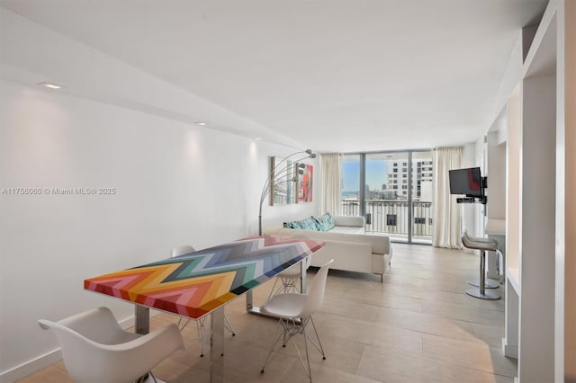 game room featuring floor to ceiling windows and baseboards