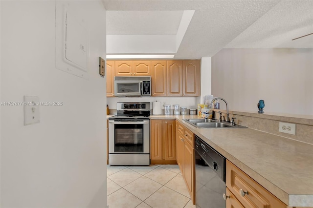 kitchen with light countertops, stainless steel appliances, light brown cabinets, a sink, and light tile patterned flooring