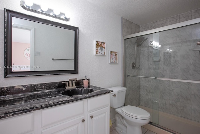 full bath with a textured wall, toilet, a textured ceiling, vanity, and a shower stall