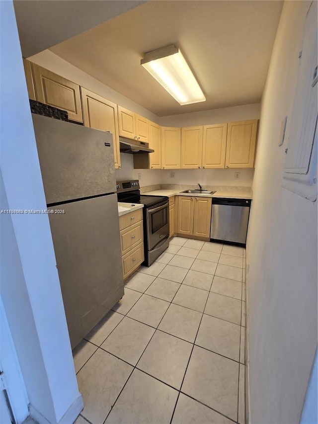 kitchen with light countertops, appliances with stainless steel finishes, light brown cabinets, a sink, and under cabinet range hood