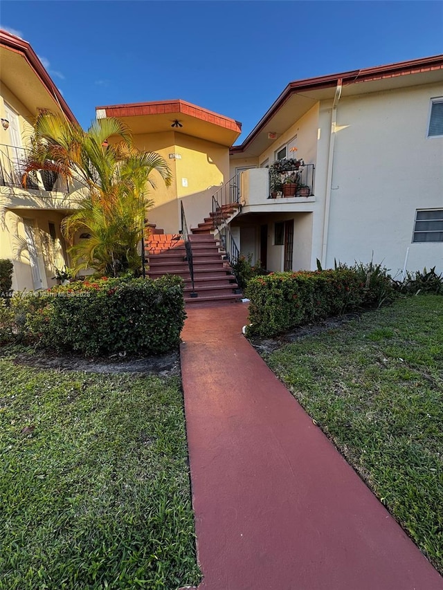 view of front facade featuring stairway and stucco siding