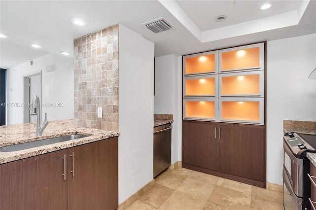 kitchen featuring light stone counters, stainless steel appliances, recessed lighting, visible vents, and a sink