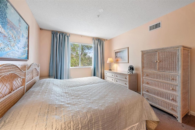 bedroom featuring visible vents, a textured ceiling, and carpet flooring