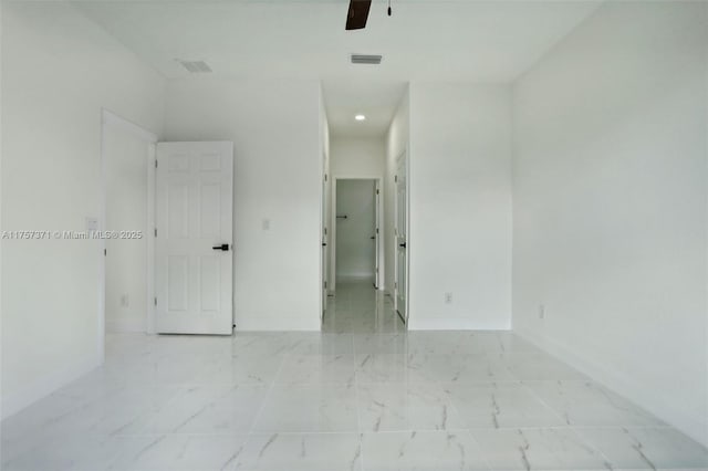 spare room featuring ceiling fan, marble finish floor, visible vents, and baseboards