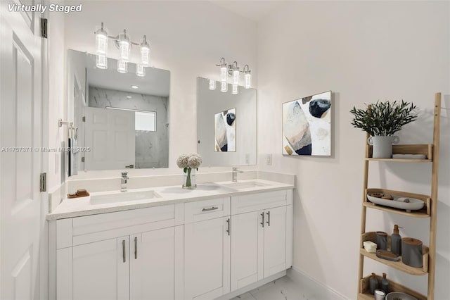 full bathroom with double vanity, marble finish floor, a marble finish shower, and a sink