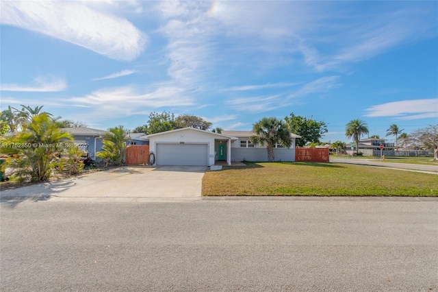 ranch-style home with a garage, a front lawn, fence, and concrete driveway