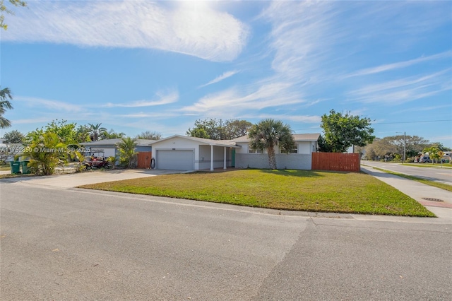 single story home featuring a garage, fence, concrete driveway, and a front yard