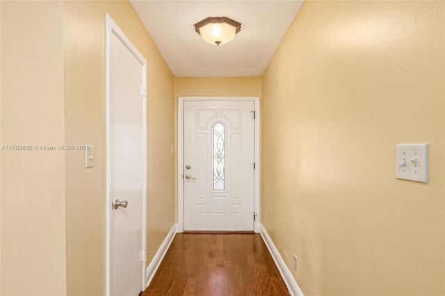 doorway featuring dark wood finished floors and baseboards