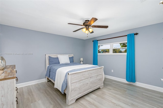 bedroom featuring a ceiling fan, baseboards, and wood finished floors