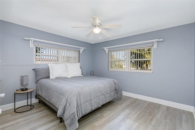 bedroom with ceiling fan, baseboards, and wood finished floors