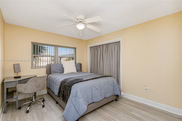 bedroom with light wood-type flooring, ceiling fan, and baseboards