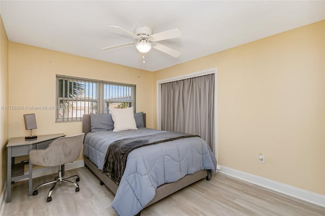 bedroom featuring light wood-style floors, a ceiling fan, and baseboards