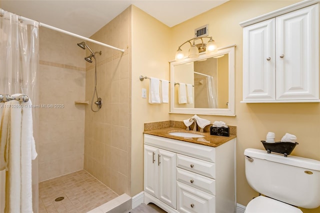 full bath featuring toilet, visible vents, vanity, and a tile shower