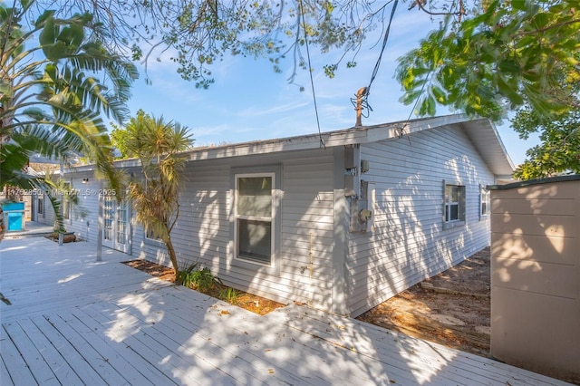 rear view of property featuring french doors and a wooden deck