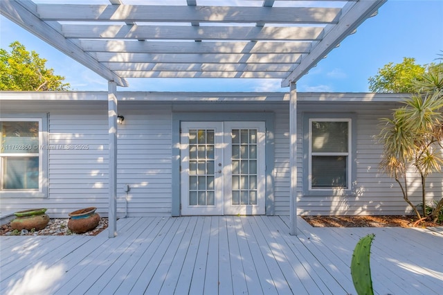 wooden terrace with a pergola and french doors