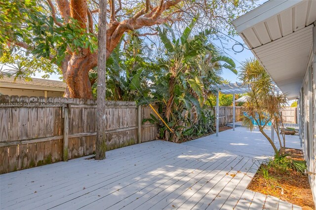 wooden deck featuring a fenced backyard and a pergola