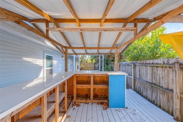 wooden terrace with a fenced backyard and outdoor dry bar
