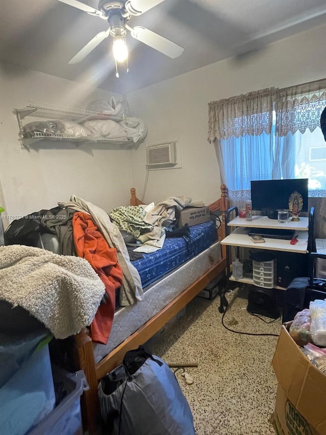 bedroom with a wall unit AC and a ceiling fan