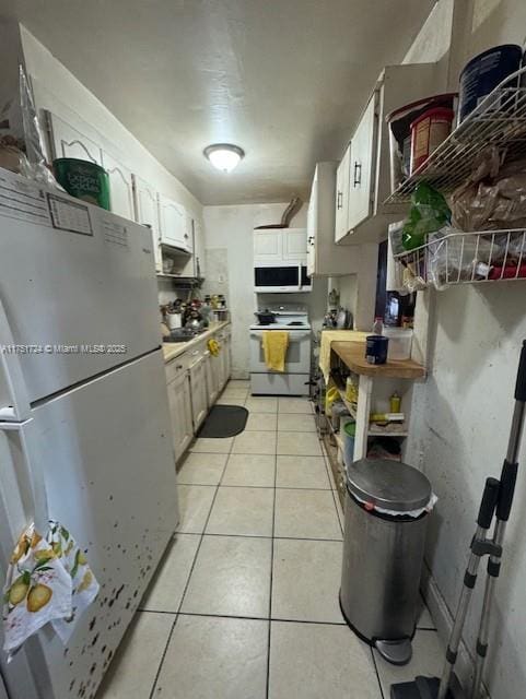 kitchen with light countertops, white appliances, white cabinets, and light tile patterned floors