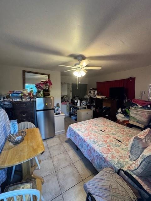 bedroom featuring freestanding refrigerator, ceiling fan, and light tile patterned floors