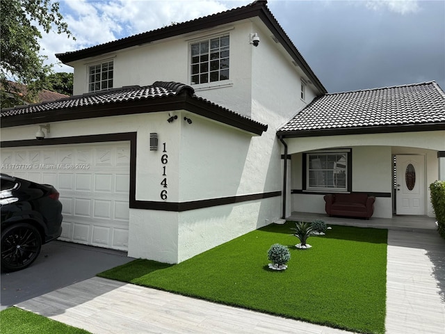 mediterranean / spanish home with a garage, concrete driveway, a tile roof, and stucco siding