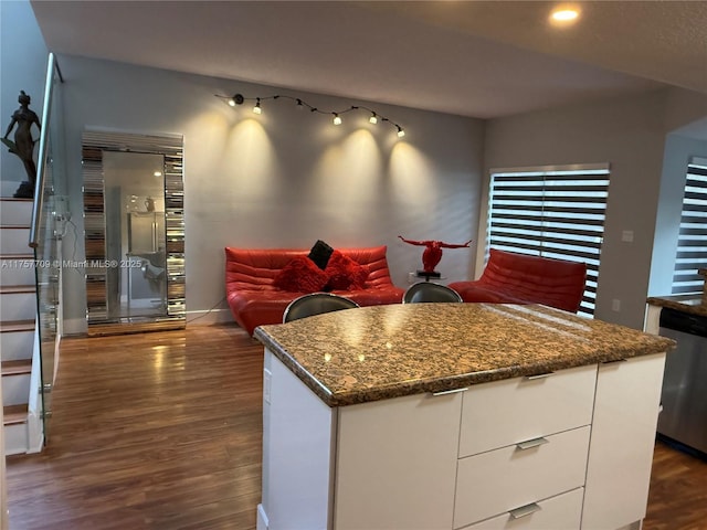 kitchen with dark wood-type flooring, baseboards, white cabinets, stainless steel dishwasher, and modern cabinets