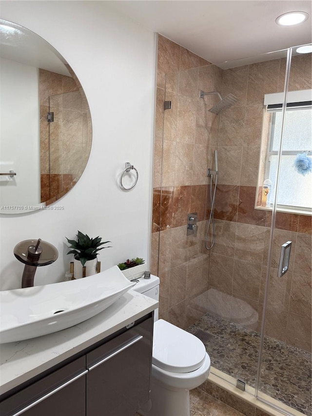 bathroom with toilet, a shower stall, recessed lighting, and vanity