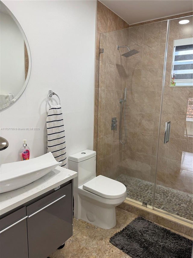 full bath with toilet, a stall shower, and vanity