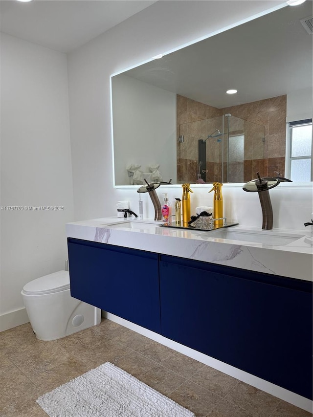 bathroom featuring toilet, a shower stall, and vanity