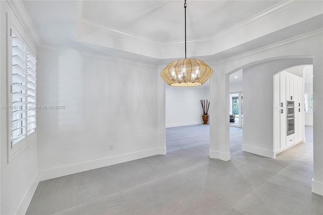 unfurnished dining area with a raised ceiling, plenty of natural light, and arched walkways