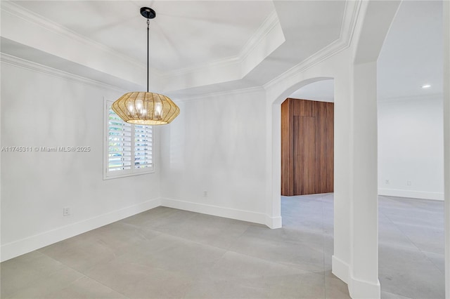 spare room featuring ornamental molding, a tray ceiling, arched walkways, baseboards, and a chandelier