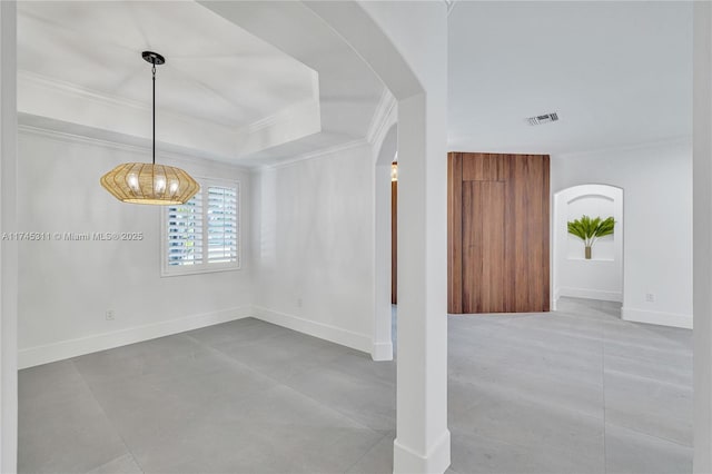 unfurnished dining area with visible vents, baseboards, a tray ceiling, arched walkways, and crown molding