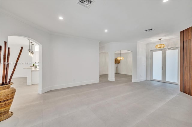 unfurnished living room featuring recessed lighting, visible vents, arched walkways, and baseboards