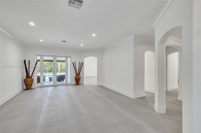 empty room with baseboards, french doors, visible vents, and arched walkways