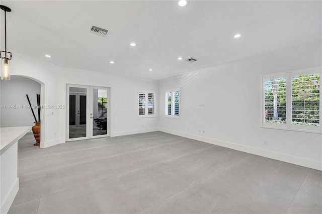 unfurnished room featuring arched walkways, visible vents, and recessed lighting
