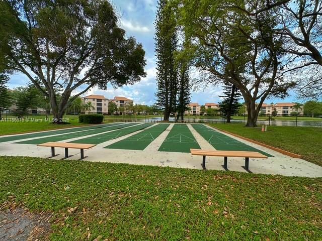 surrounding community featuring shuffleboard and a yard