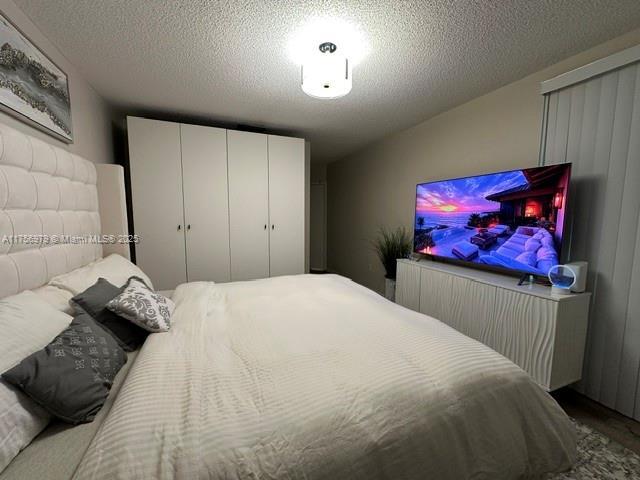 bedroom with a textured ceiling and a closet