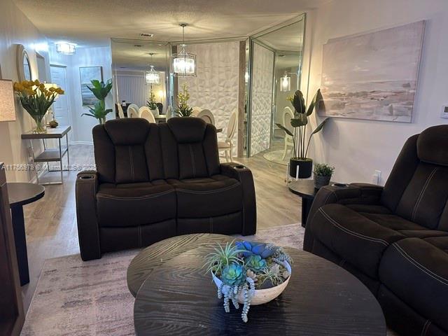 living area featuring a notable chandelier and wood finished floors