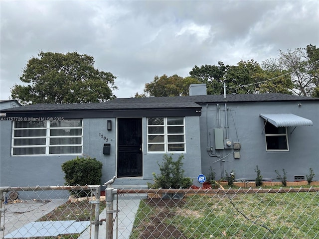 view of front of house with crawl space, stucco siding, a fenced front yard, and a front yard